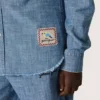 Koszulka unisex Journey z jasnoniebieskiej bawełny typu chambray z frędzlowym wykończeniem i haftowaną naszywką