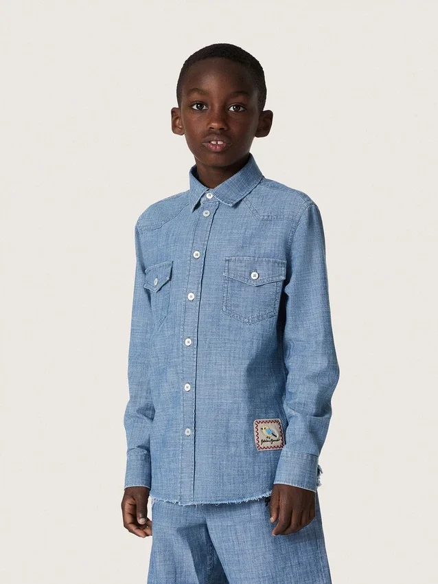 Koszulka unisex Journey z jasnoniebieskiej bawełny typu chambray z frędzlowym wykończeniem i haftowaną naszywką