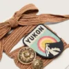 Skóry – sznurowadła w kolorze bordowym i brzoskwiniowym z haftem, naszywką i dwoma zawieszkami