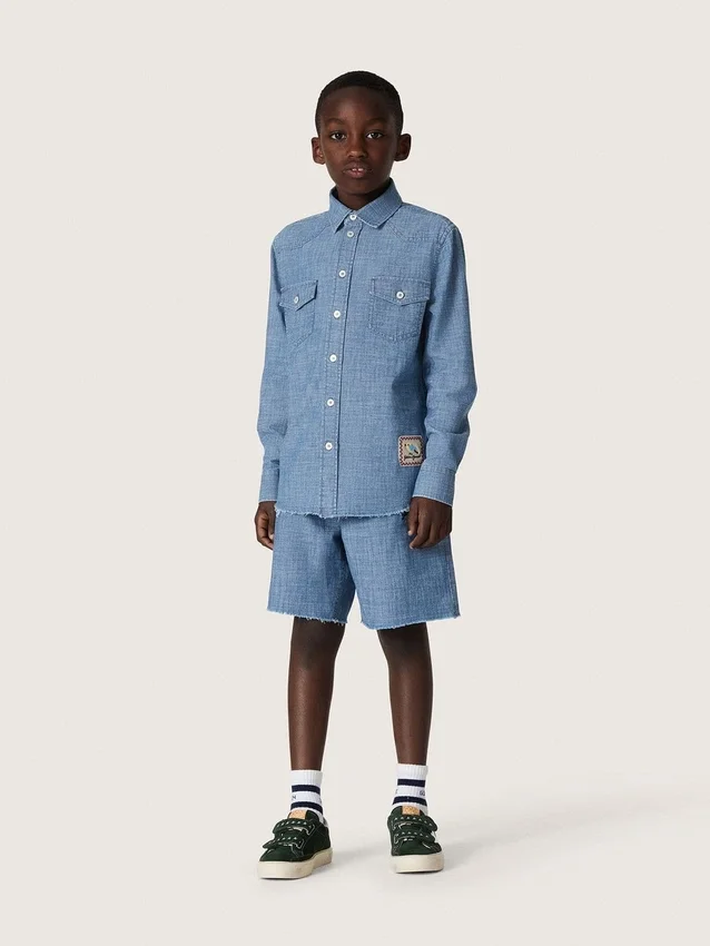 Koszulka unisex Journey z jasnoniebieskiej bawełny typu chambray z frędzlowym wykończeniem i haftowaną naszywką